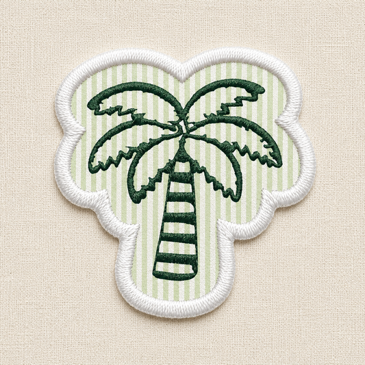 A close-up of an embroidered patch. In the center is a detailed green palm tree, set against a background of alternating horizontal stripes in a seersucker pattern. The entire patch is enclosed by a clean, raised white merrowed border.